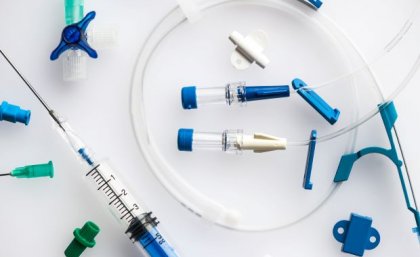 plastic tubing with blue clips, taps and end pieces and a syringe with needs attached 